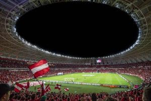 Exciting soccer match with enthusiastic fans in a packed stadium under bright lights.