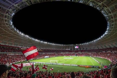Les paris en ligne : comment pouvons-nous vraiment gagner ? Voici les méthodes des plateformes Exciting soccer match with enthusiastic fans in a packed stadium under bright lights.