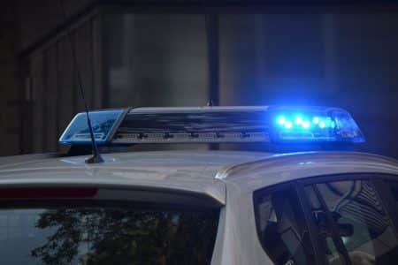 L’ombre du Caucase : l’infiltration des mafias post-soviétiques en France Close-up of a police car's flashing blue lights in an urban environment.