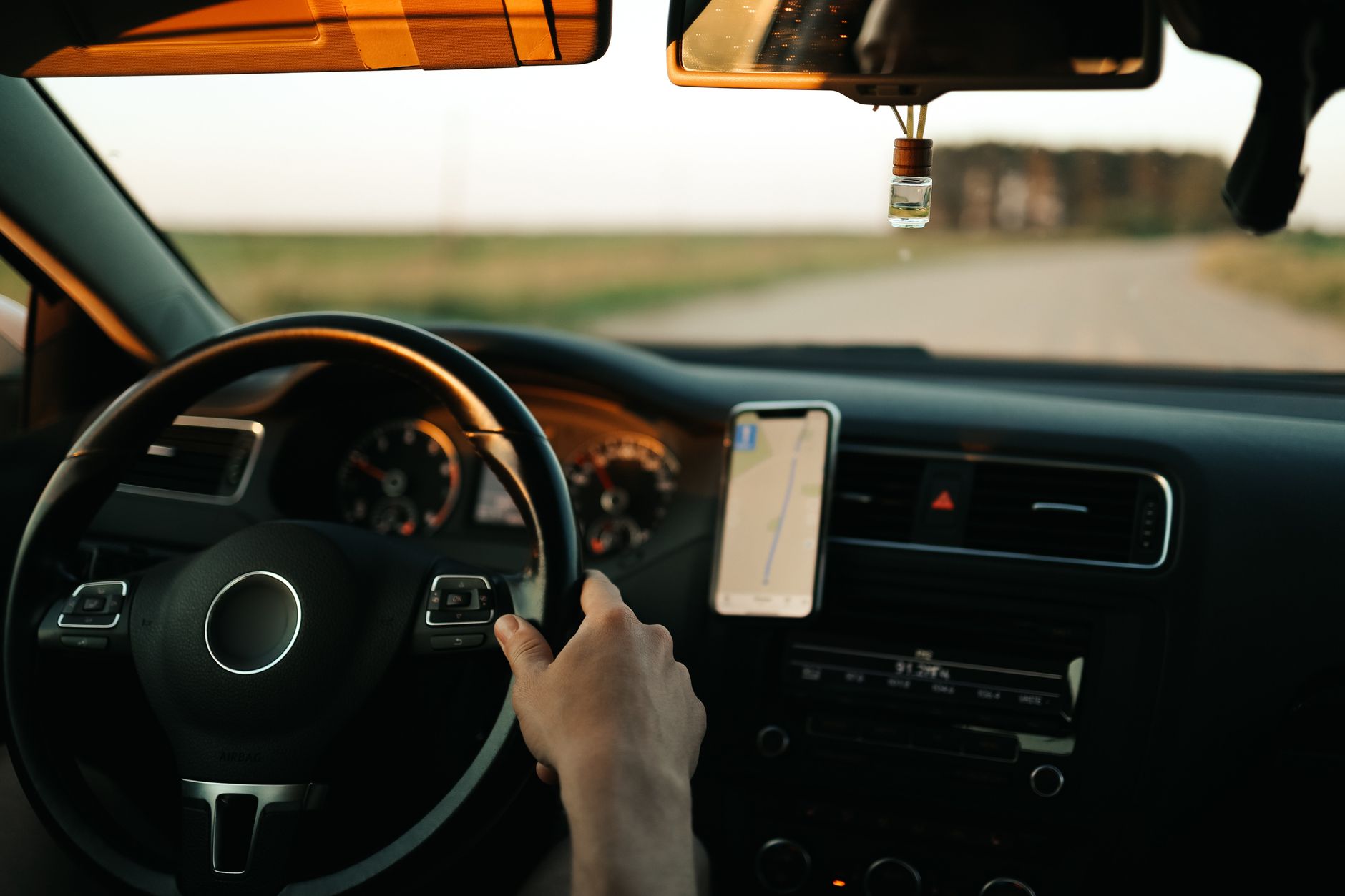 Intérieur d'une voiture avec navigation GPS, se concentrant sur le conducteur et le tableau de bord pendant la journée.